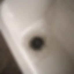 A close-up of a clogged bathtub drain with hair and debris